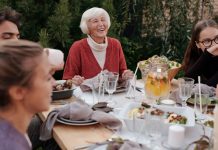 Bayonne hospital, city host first senior health event Smiling elderly woman with family and friends enjoying dinner at table backyard garden