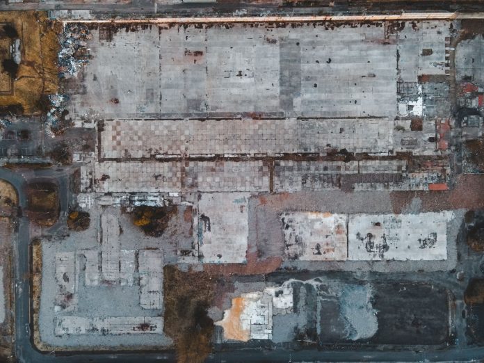 Drone shot of a large vacant lot in Scotland, showcasing concrete and debris.