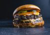 Mouth-watering beef cheeseburger with pickles, perfect for gourmet food photography.