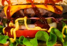Mouth-watering close-up of a cheeseburger with toppings, showcasing textures and rich flavors.