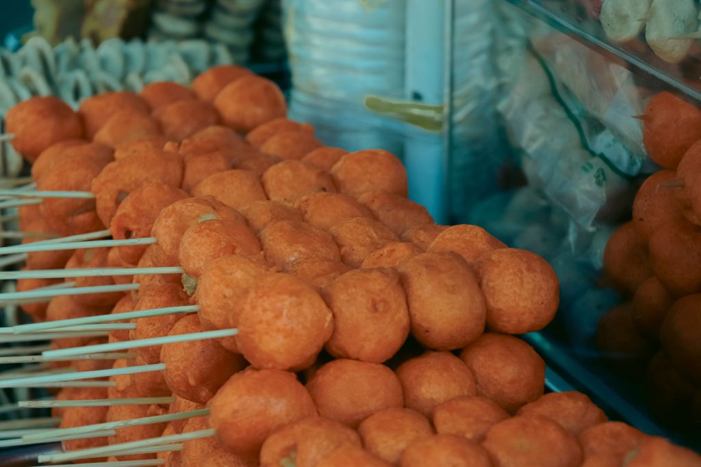 Close-up of skewered fried street food balls, perfect for food and travel visuals.