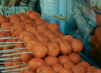 Close-up of skewered fried street food balls, perfect for food and travel visuals.