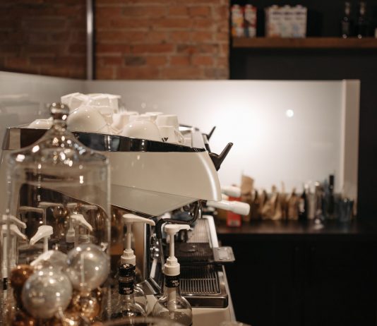 A cozy coffee shop interior featuring a modern espresso machine and various coffee accessories.