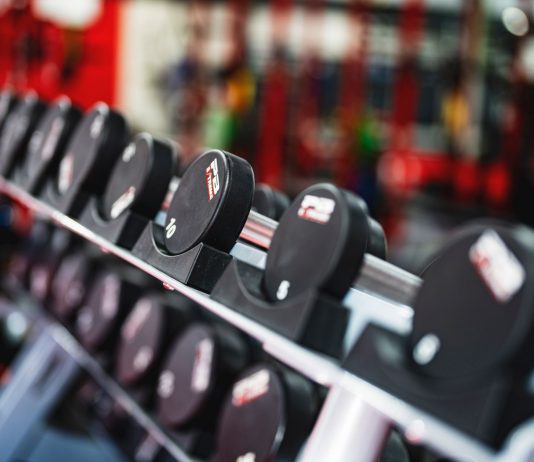 Close-up view of dumbbells in a modern gym setting, emphasizing fitness and training.