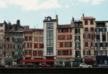 Best Neighborhoods to Live in Bayonne, NJ (2026 Guide) Charming traditional buildings along the Nive River in Bayonne, France, showcasing unique Basque architecture.