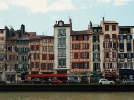 Best Neighborhoods to Live in Bayonne, NJ (2026 Guide) Charming traditional buildings along the Nive River in Bayonne, France, showcasing unique Basque architecture.