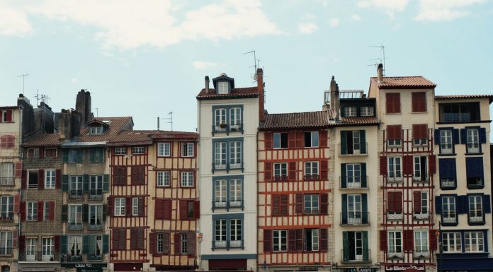Charming traditional buildings along the Nive River in Bayonne, France, showcasing unique Basque architecture.