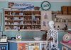 A nostalgic view inside an old-timey pharmacy featuring vintage medicine bottles and a medical skeleton on display.