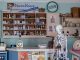 A nostalgic view inside an old-timey pharmacy featuring vintage medicine bottles and a medical skeleton on display.
