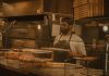 Best Pizza in North Bergen in 2026: A Local’s Guide to the Slice Pizza chef serving slices in a Milwaukee pizzeria, captured in warm tones.