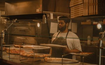 Best Pizza in North Bergen in 2026: A Local’s Guide to the Slice Pizza chef serving slices in a Milwaukee pizzeria, captured in warm tones.