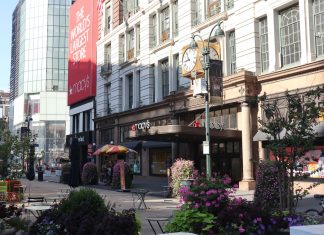 Daytime view of Macy's storefront in New York City, showcasing urban architecture and bustling streets.