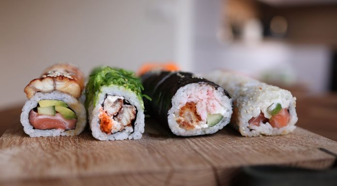 Close-up of assorted sushi rolls on a wooden board showcasing fresh ingredients.