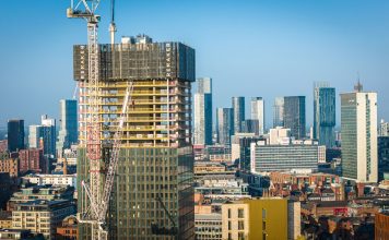 Aerial view of modern skyscrapers in Manchester with ongoing construction highlighting urban growth.