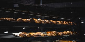 A variety of freshly baked pastries and breads in a glass display case at a bakery.