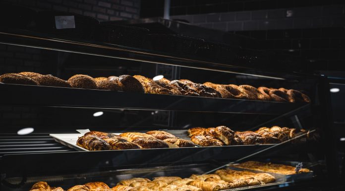 A variety of freshly baked pastries and breads in a glass display case at a bakery.