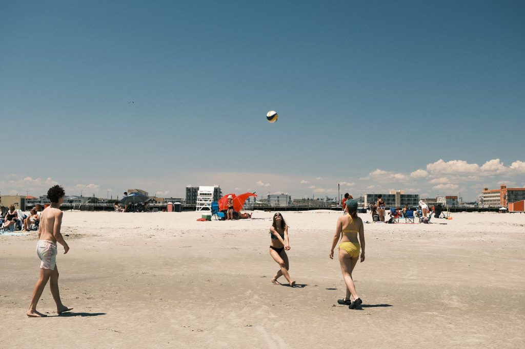 A lively beach volleyball game under a clear sky at Cape May, New Jersey.