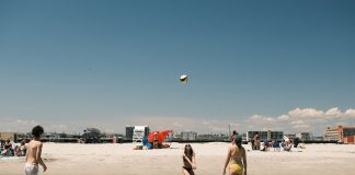 A lively beach volleyball game under a clear sky at Cape May, New Jersey.