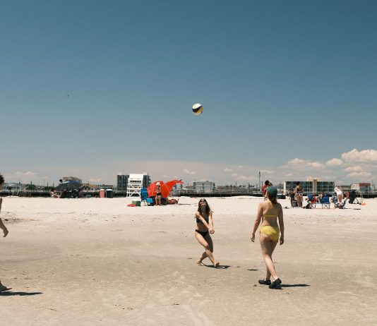 A lively beach volleyball game under a clear sky at Cape May, New Jersey.