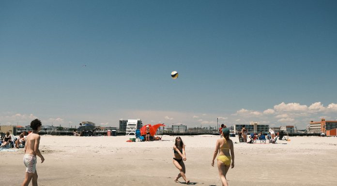 A lively beach volleyball game under a clear sky at Cape May, New Jersey.