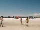 A lively beach volleyball game under a clear sky at Cape May, New Jersey.
