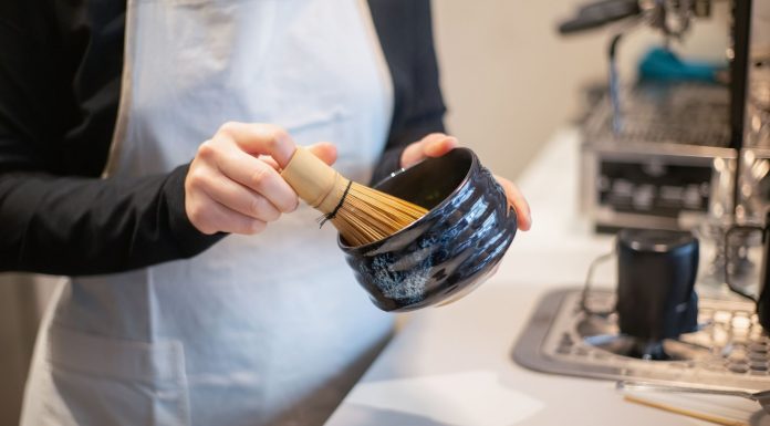BREAKING: Jane’s Matcha Opens First Brick-and-Mortar in Jersey City Close-up of a person preparing matcha tea using a bamboo whisk and bowl indoors.