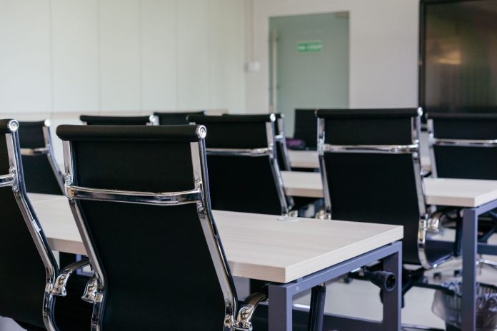 breaking-jersey-city-health-department-presents-8- Sleek modern conference room with black chairs and white desks, suitable for business meetings.