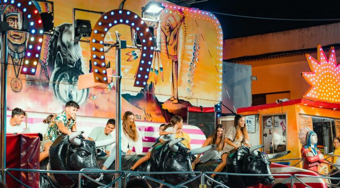 BREAKING: Jersey City Italian Festival Returns for 124th Year in August People enjoying a vibrant bull ride at an outdoor funfair at night.