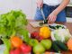 BREAKING: Just Salad Plans Second Jersey City Location at 99 Hudson Woman slicing cucumbers surrounded by fresh produce in a bright kitchen setting.