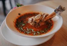 Delicious lamb shank soup garnished with fresh herbs, perfect for a cozy meal.