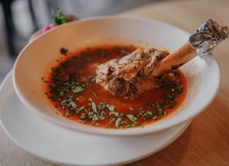 Delicious lamb shank soup garnished with fresh herbs, perfect for a cozy meal.