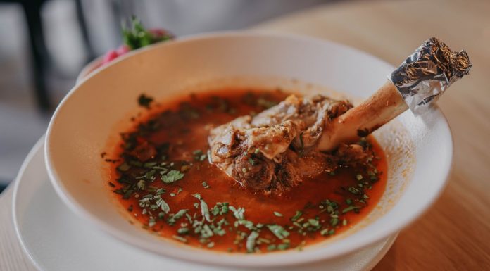 Delicious lamb shank soup garnished with fresh herbs, perfect for a cozy meal.