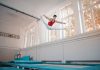BREAKING: Unique Fitness Classes to Try in Jersey City and Hoboken Young sportsman in sportswear doing split in air while jumping on trampoline in gym
