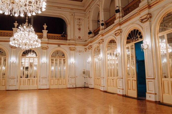 Elegant concert hall with chandeliers and ornate decor in Maribor, Slovenia.