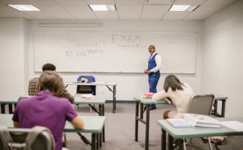 A college educator proctoring an exam, enforcing no cheating rules.
