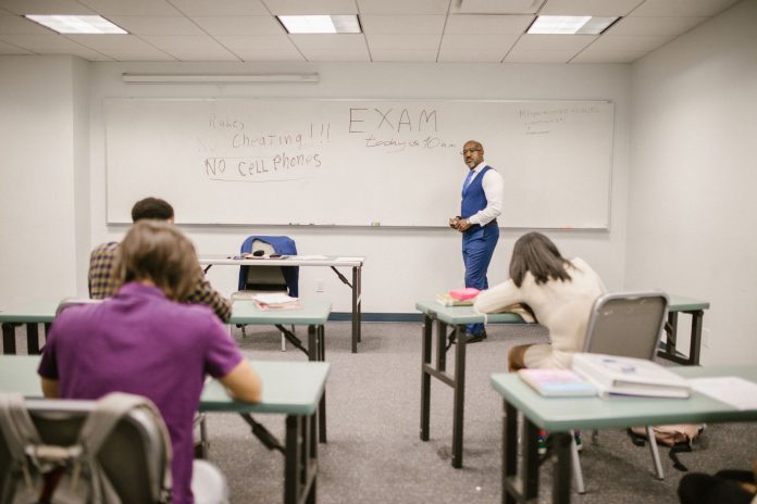 como-obtener-ged-union-city-nj-guia-completa-2026 A college educator proctoring an exam, enforcing no cheating rules.
