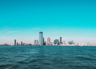 Panoramic view of Manhattan skyline with modern skyscrapers under a clear blue sky.