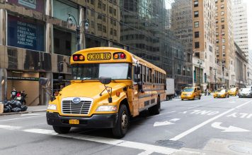 How to Enroll Your Child in West New York Public Schools (2026 Guide) A yellow school bus navigates a busy New York City street amidst tall buildings and taxis.