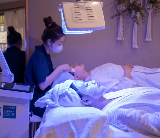 Patients receiving LED light therapy and facial treatment in a spa setting.