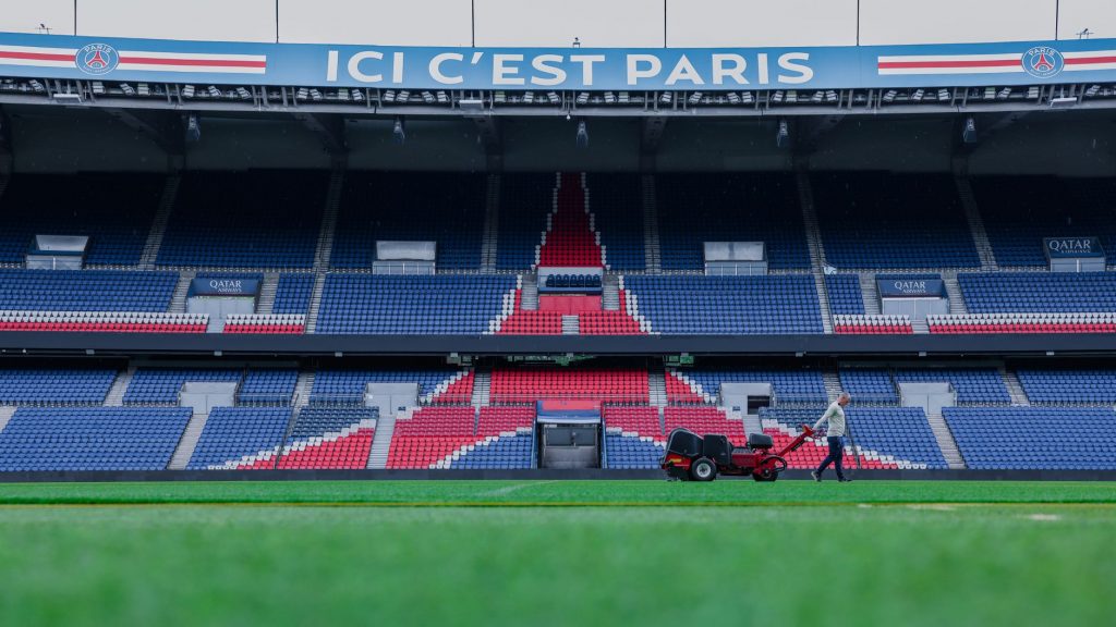 Gardener working on the field at Parc des Princes stadium, Paris. Vibrant and iconic sports venue.