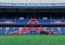 Gardener working on the field at Parc des Princes stadium, Paris. Vibrant and iconic sports venue.