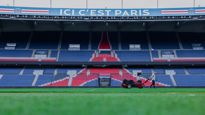 fifa-sells-450-world-cup-final-grass-from-metlife- Gardener working on the field at Parc des Princes stadium, Paris. Vibrant and iconic sports venue.