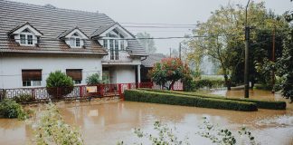 Flood Watch Issued for Jersey City as Storm System Approaches A suburban house surrounded by floodwaters after heavy rain, showing impact of natural disaster.