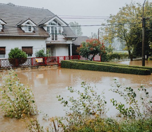 Flood Watch Issued for Jersey City as Storm System Approaches A suburban house surrounded by floodwaters after heavy rain, showing impact of natural disaster.