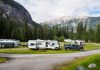 A beautiful campsite featuring RVs amidst lush forests and towering mountains for a peaceful getaway.