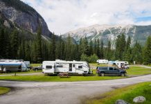 A beautiful campsite featuring RVs amidst lush forests and towering mountains for a peaceful getaway.