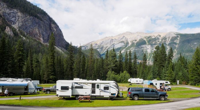 A beautiful campsite featuring RVs amidst lush forests and towering mountains for a peaceful getaway.