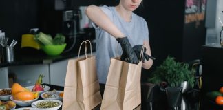 Hoboken’s Ready Strong Meals Brings Healthy Eating Home A person in a kitchen packing food ingredients into paper bags for takeout orders.