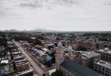 Aerial view showcasing Philadelphia's skyline and urban landscape with a historic church in the foreground.
