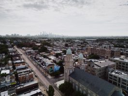 Aerial view showcasing Philadelphia's skyline and urban landscape with a historic church in the foreground.